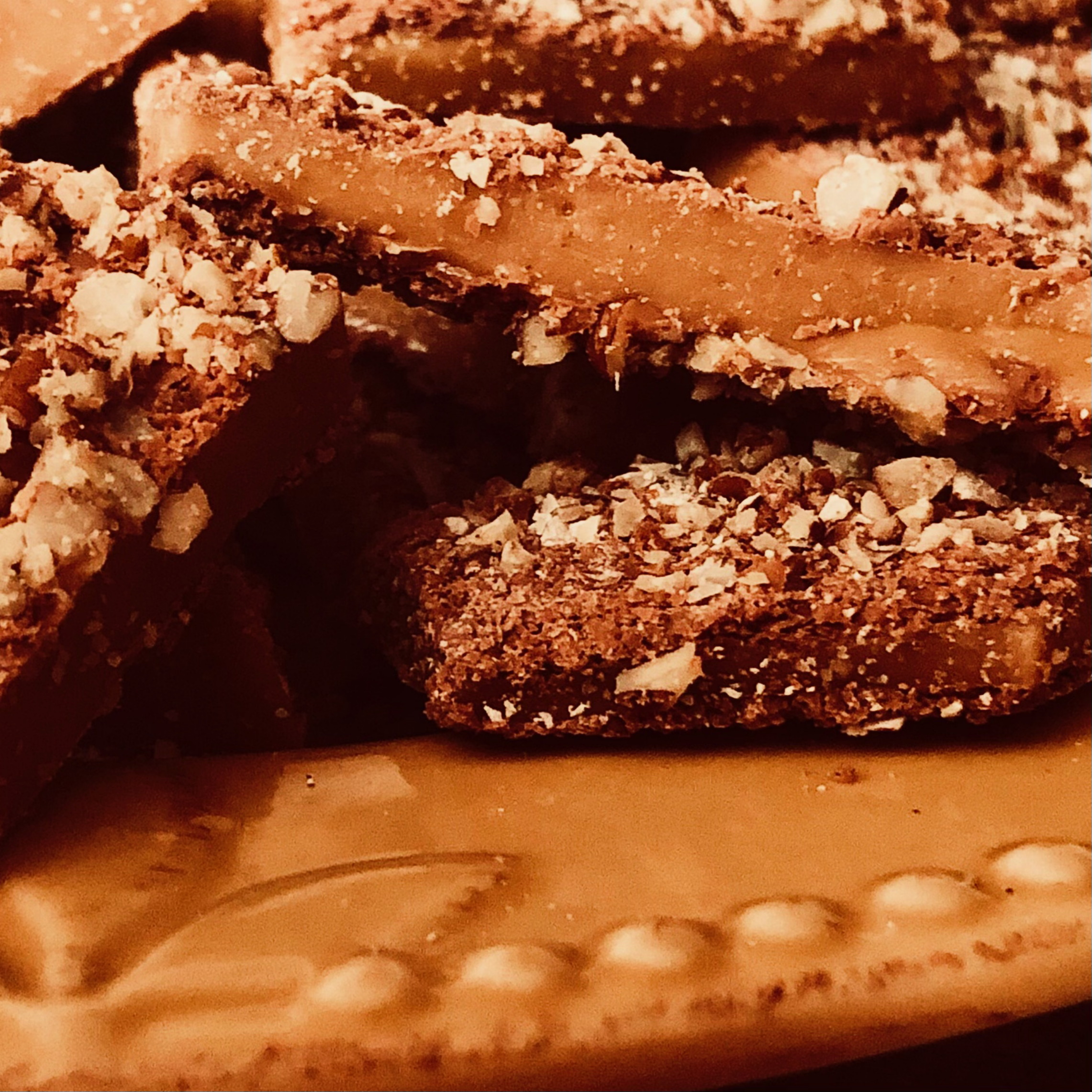 Stacked toffee pieces with chocolate and chopped nuts
