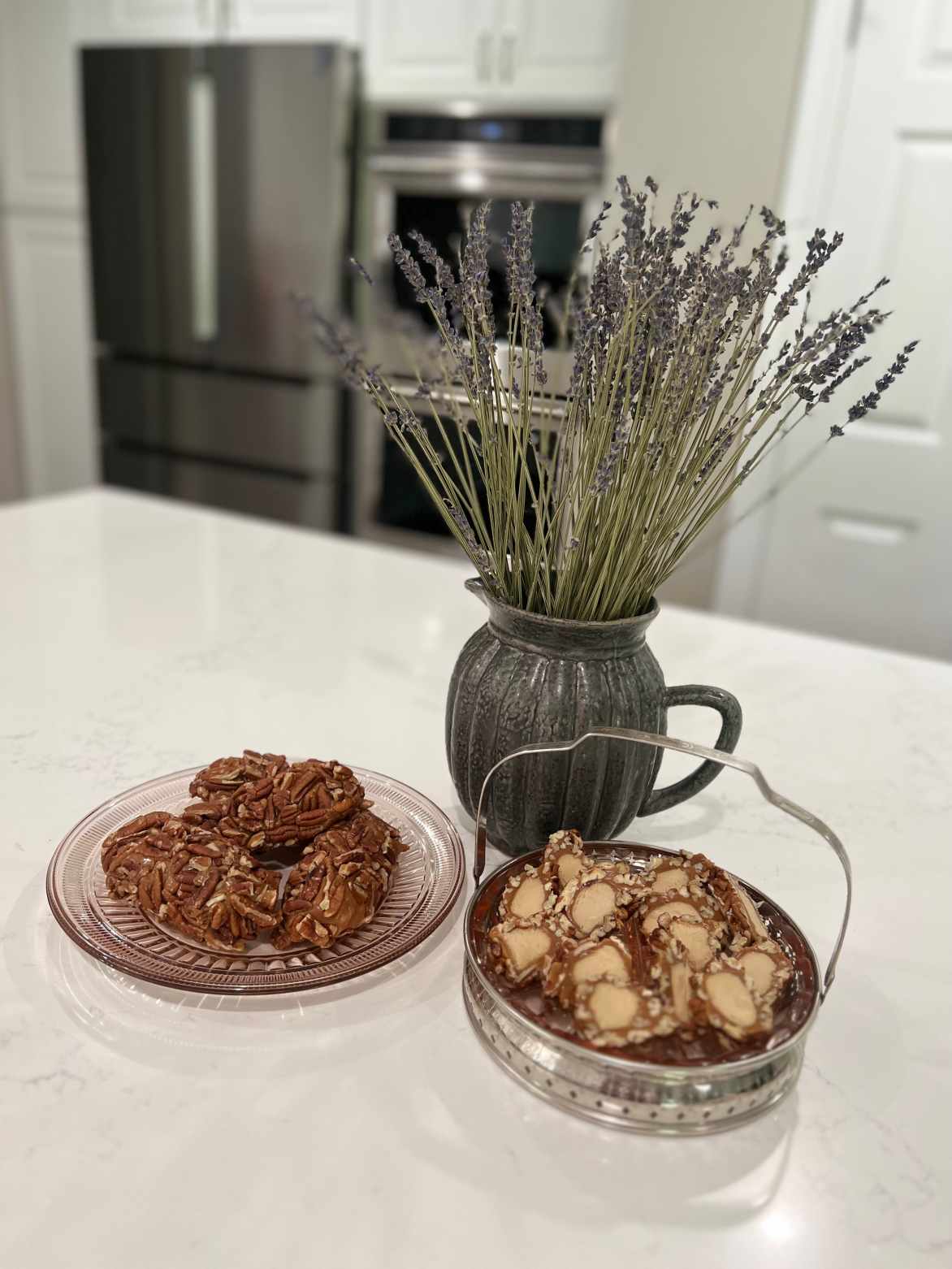 Pecan logs, whole and sliced with lavender flowers in a pitcher
